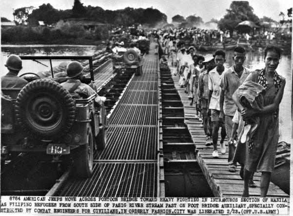As fighting rages in and around Manila, the capital of the Philippines, refugees pour out of the city. This bridge was built by US engineers